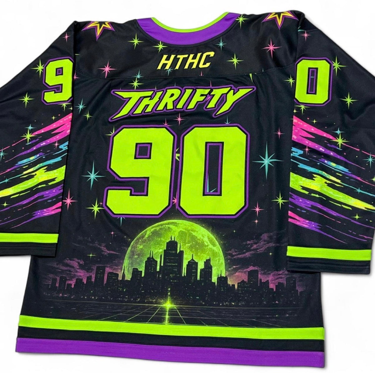 A black long-sleeve hockey-style jersey laid flat, featuring neon lime green, purple, and pink graphics. The back shows the text 'HTHC THRIFTY 90' with large neon numbers, and the sleeves have colorful starburst and streak motifs.