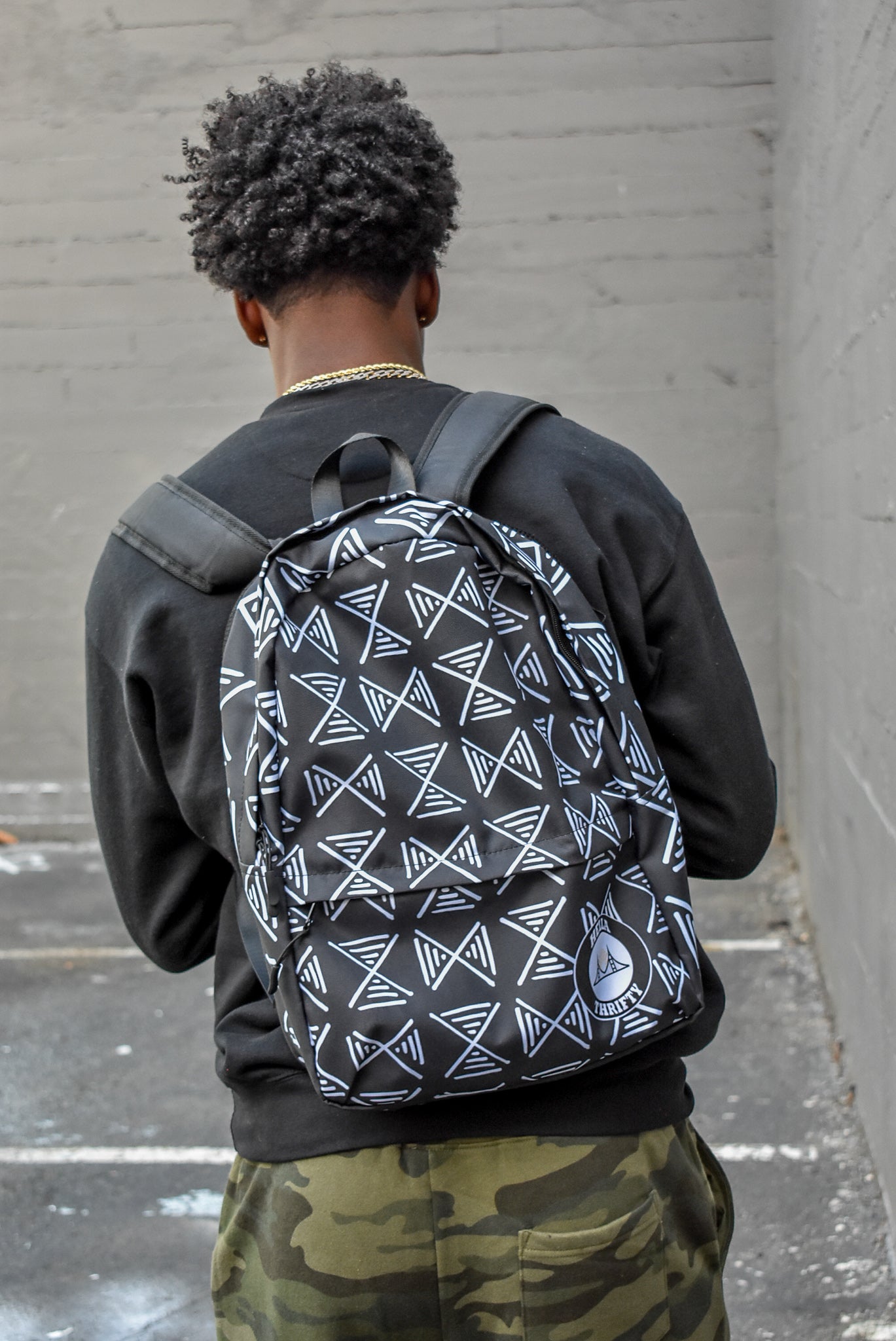 Model with black african print backpack.