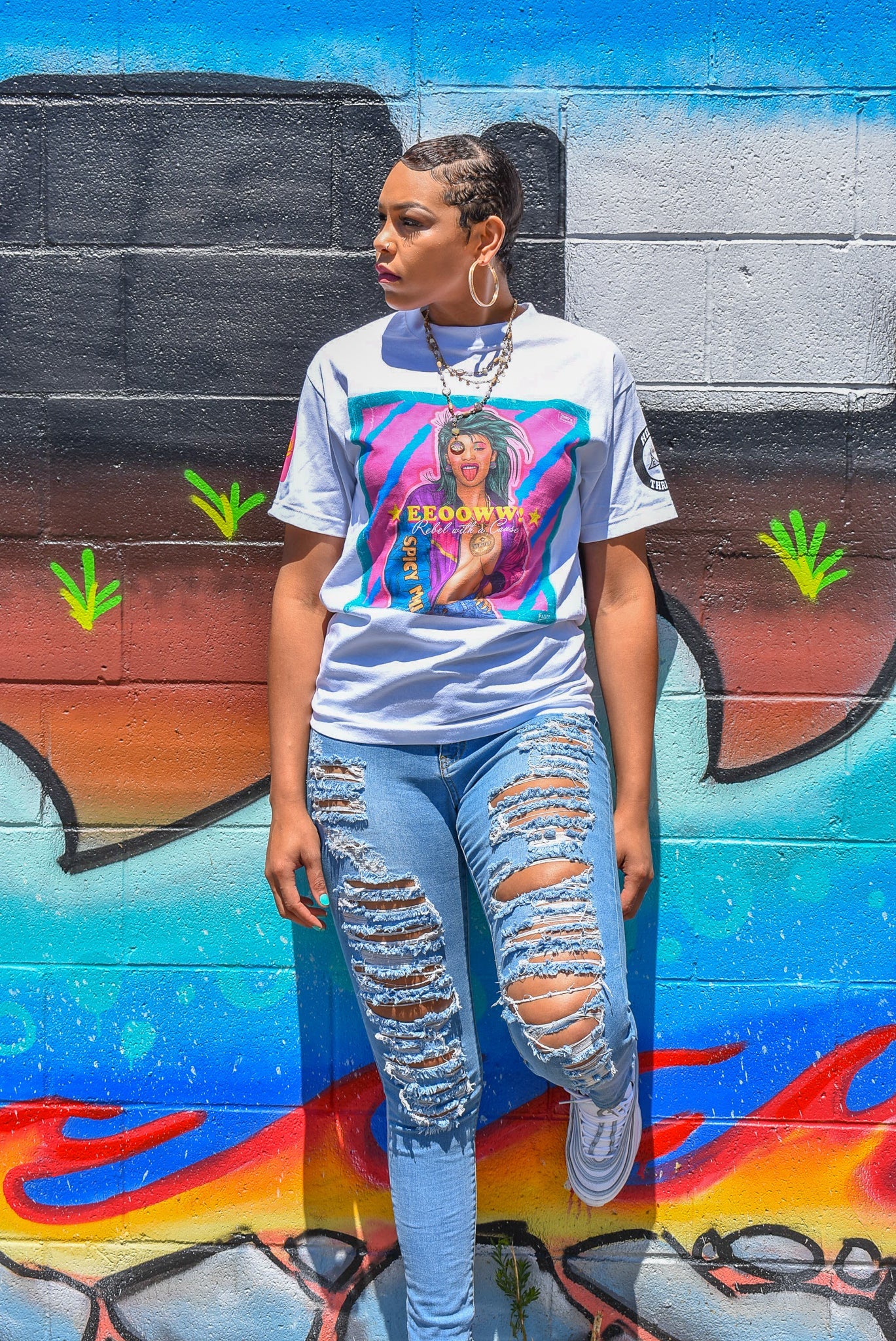 Female model wearing the Cardi B tee with blue ripped jeans.